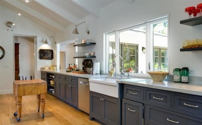 Modern farmhouse galley kitchen with black cabinets with white farmhouse sink and stainless steel appliances 