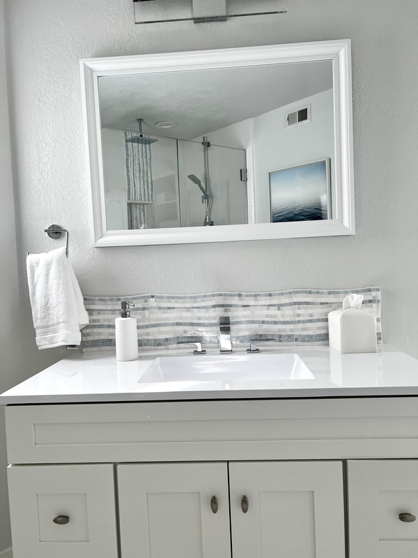 Coastal design white vanity with white Quartz countertop and backsplash