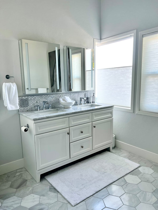 Coastal design gray and white penny round tile backsplash in Master bathroom