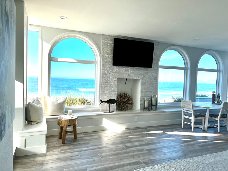 Modern Coastal design with custom bench white natural stone fireplace and light wood-look porcelain tile flooring in living room