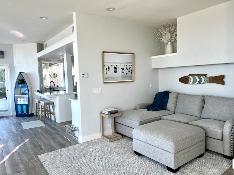Modern Coastal design with light wood-look porcelain tile flooring in living room