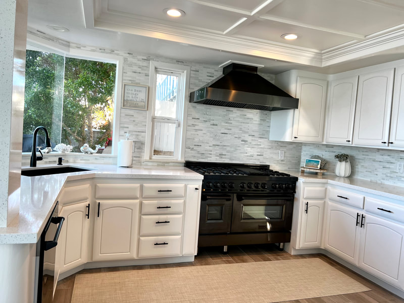 Modern Coastal design with black appliances and natural stone backsplash in kitchen 